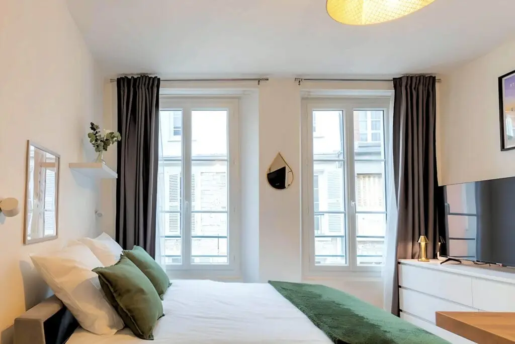 Bright bedroom with large windows and modern decor.